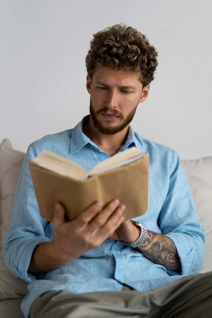 Un chico joven leyendo un libro en la casa de una persona mayor